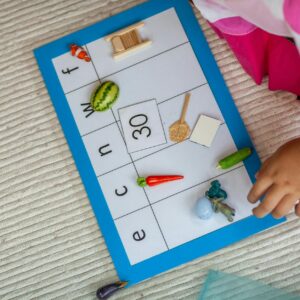 Child interacting with Montessori educational mat engaging in preschool learning activity.