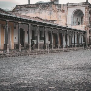 Elegant colonial buildings with stone archways and cobblestone streets in Antigua Guatemala.